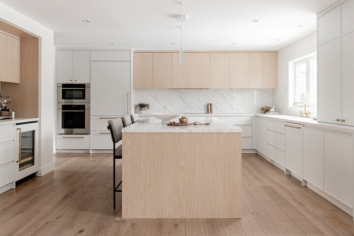 Kitchen with white cabinets and marble countertops.