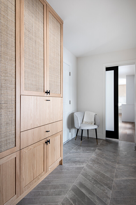 Mudroom with wooden cabinets and a chair.